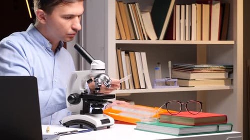 Scientist Using Microscope Conducting Research in Laboratory