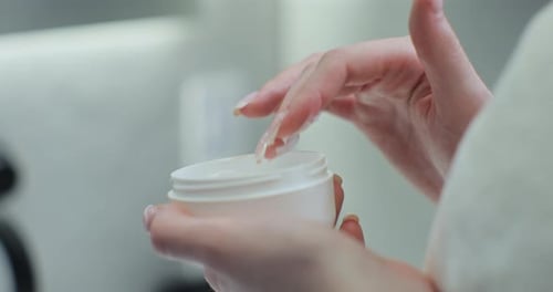 Woman Takes a White Hand Cream From a White Jar with Her Finger Close Up Skin Care Skin Moisturize