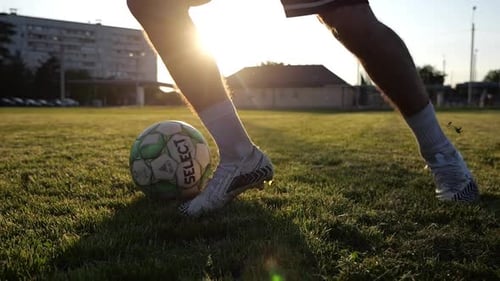 Male Feet of Professional Footballer Shows Tricks with Ball While Running at Green Field Legs of
