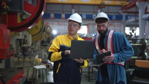 Engineer and technician discussing machinery in factory to plan inspection maintenance