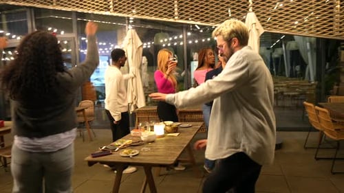 Latin Woman Dancing While Partying with Friends at Roof Bar
