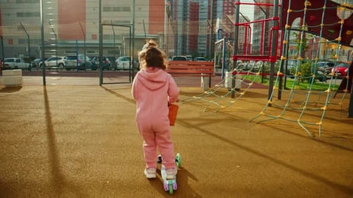 A Joyful Young Child Riding a Colorful Scooter in a Vibrant Playground Experiencing the Thrill of