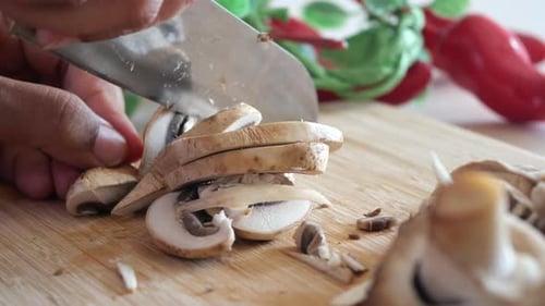 Cutting Fresh Champignons Mushroom on a Chopping Board