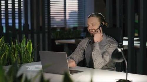 Caucasian Businessman at Office Workplace with Laptop Working Smiling Talking Mobile Phone