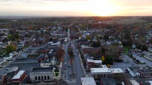Rising aerial of American town at night. Sunset on horizon. USA small town Americana theme.