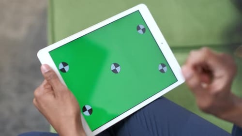 Uma mulher negra com um tablet na mão. Toque em gestos na tela sensível ao toque.