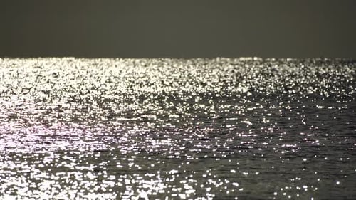 Abstrakte strahlende Sonnenreflexionen auf der blauen Oberfläche von Meereswellen