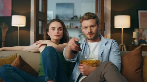 Couple Relaxing Together on Couch Eating Chips