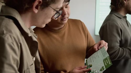 Asian Man with Teenager Reading Brochure in Support Group Session