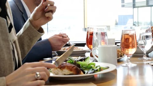Business people enjoying working lunch at restaurant with teamwork