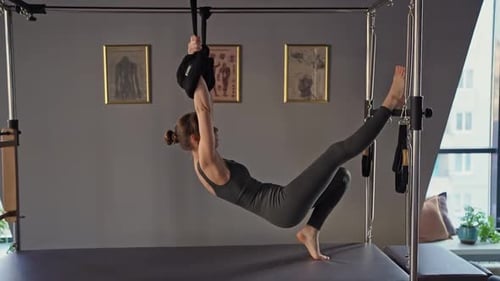 Pilates Fitness Trainer Doing Back Strengthening Exercises on in Pilates Studio Balanced Body