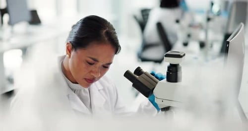 Woman Using Microscope in Modern Laboratory