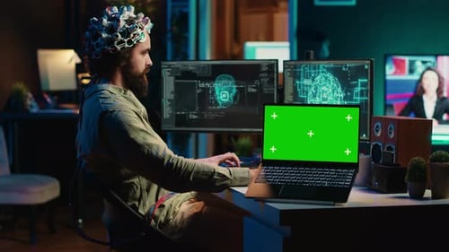 Engineer with EEG Headset on Merging with AI Green Screen Laptop