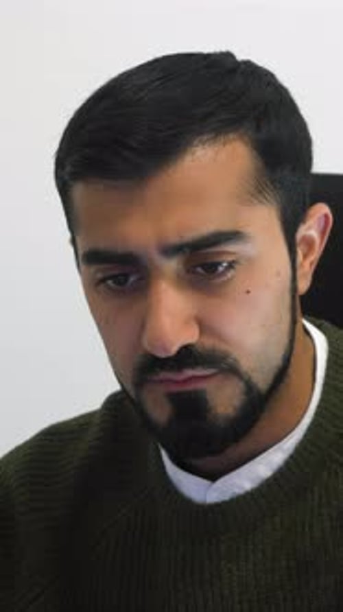 Portrait of a Young Businessman Working on Laptop in Office Against White Wall HDR Serious Male