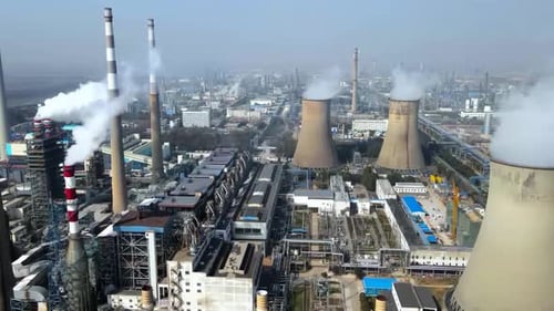 Energy factory with structure and tower cranes at industrial production area. Greenhouse gas smoke p