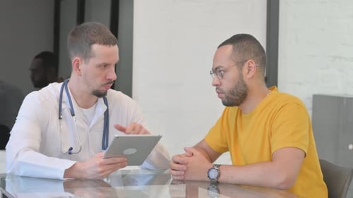 Man in Medical Coat Explains Tablet to Patient