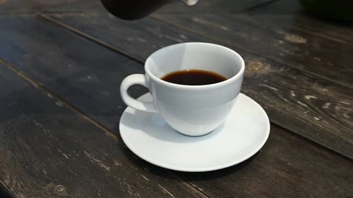 Pouring Coffee into White Mug on Rustic Table