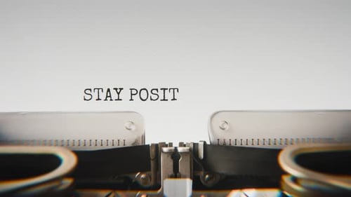 Old mechanical typewriter typing Stay Positive Keep Pushing Forward in a close-up view.