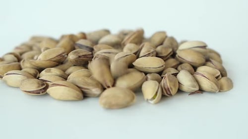 Slow Motion of Pistachios Nuts Dropping on White Background