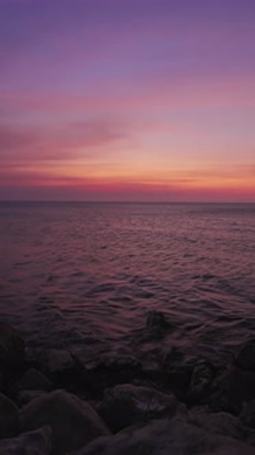 Tranquil Sunset Over A Calm Sea With Purple And Orange Sky In Santa Marta, Colombia. - vertical shot