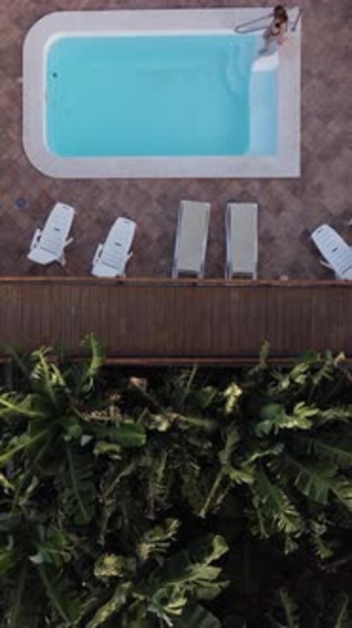 Aerial View of a Beautiful Pool Area Surrounded By Comfy Chairs