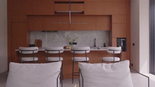 Modern Kitchen Interior with Wooden Cabinets Bar Stools and Marble Backsplash