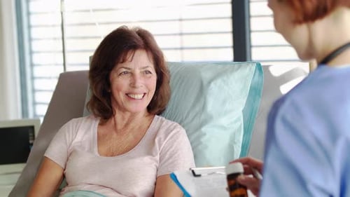 Doctor explaining treatment to senior patient lying in hospital bed