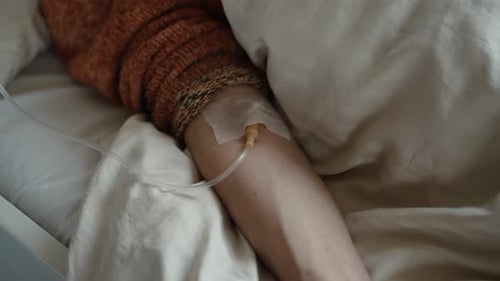 Hand with Attached IV Drip or Cannula Receiving Fluids