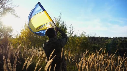 Male Military in Uniform Waving Flag of Ukraine at Countryside Young Soldier of Ukrainian Army