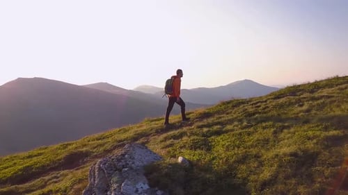 Tourist Hiker with a Backpack Walking on Mountain Path in Carpathian Mountains