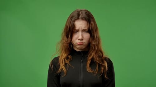 Teenager-Mädchen posiert vor der Kamera mit traurigem, verärgertem, schmollendem Gesicht und Tränenausdruck isoliert auf Chroma Key