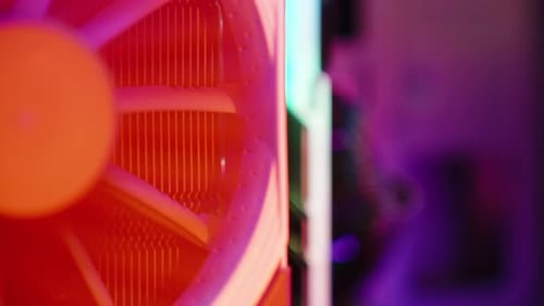 Close-up of a rotating cooler with a radiator for the processor in a PC, multicolored RGB lighting.
