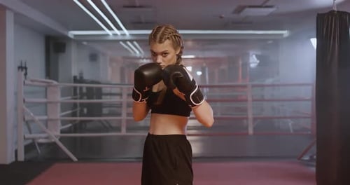 Woman Pro Fighter Trains His Punches Training in the Boxing Gym Fighter Takes a Fighting Stance and