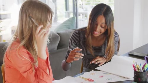 Des amies adolescentes heureuses et diversifiées parlant et apprenant ensemble à la maison, Ralenti