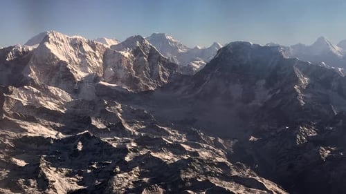 An aerial view flyby of the Himalayan Mountains of Nepal on a clear day.