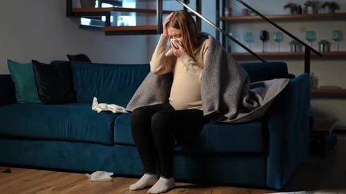 Pregnant Woman with Cold Blows Her Nose