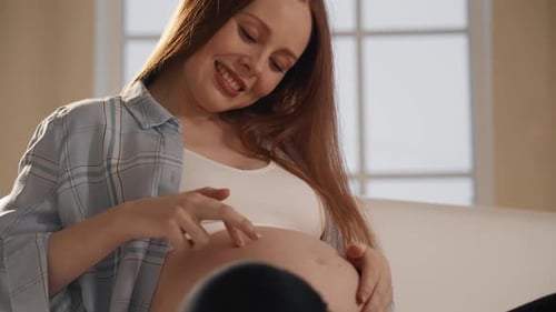 Smiling Pregnant Woman Touches Her Belly