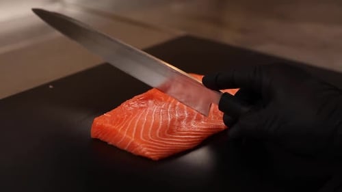 Fresh Salmon Being Cut on Cutting Board