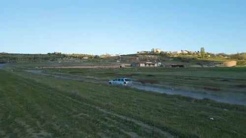 Car Driving Through Rural Landscape in Daytime