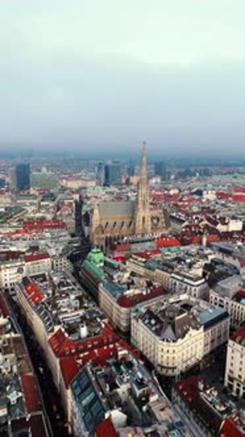 aerial drone shot portrait moving away from St Stephens cathedral in Vienna with clouds in winter