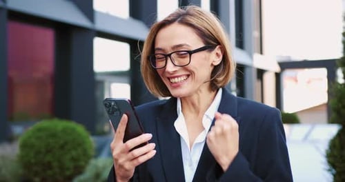 Excited Woman Celebrating Good News on Smartphone