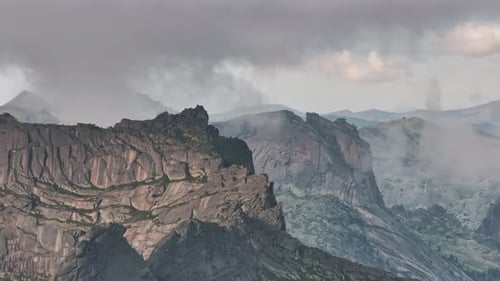 Clouds Embracing Majestic Mountain Peaks