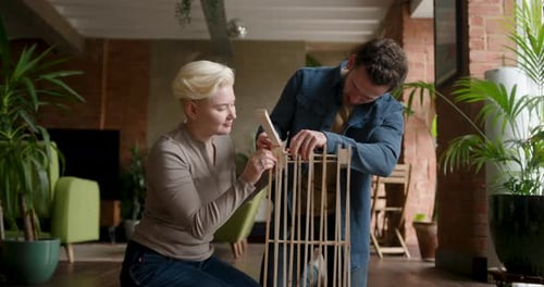 Couple laughing and putting furniture together in their new home
