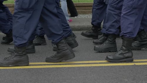 Soldiers march together on a street