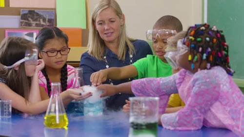 Teacher and Group of Students Make a Science Experiment in School Classroom African