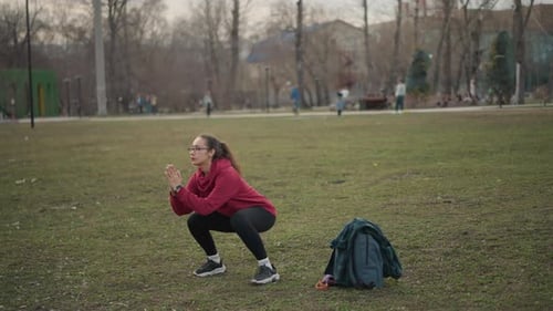 Young Woman Jogging Dynamic Park Stride With Backpack Rhythmic Running Steps Across Grass Casual