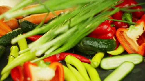 Fresh Green Onions Fall on Colorful Vegetables Laid Out on the Table
