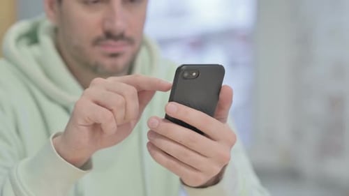 Close up of Young Man Browsing Internet on Smartphone