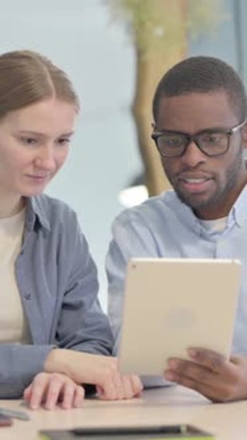Colleagues Working Together on Tablet in the Office