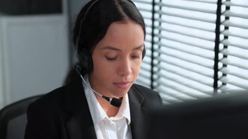 Kompetente Bedienerin, die am Computer arbeitet und mit Kunden spricht